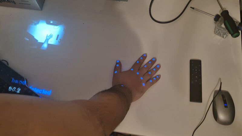 A hand interacting with an interface on a desk